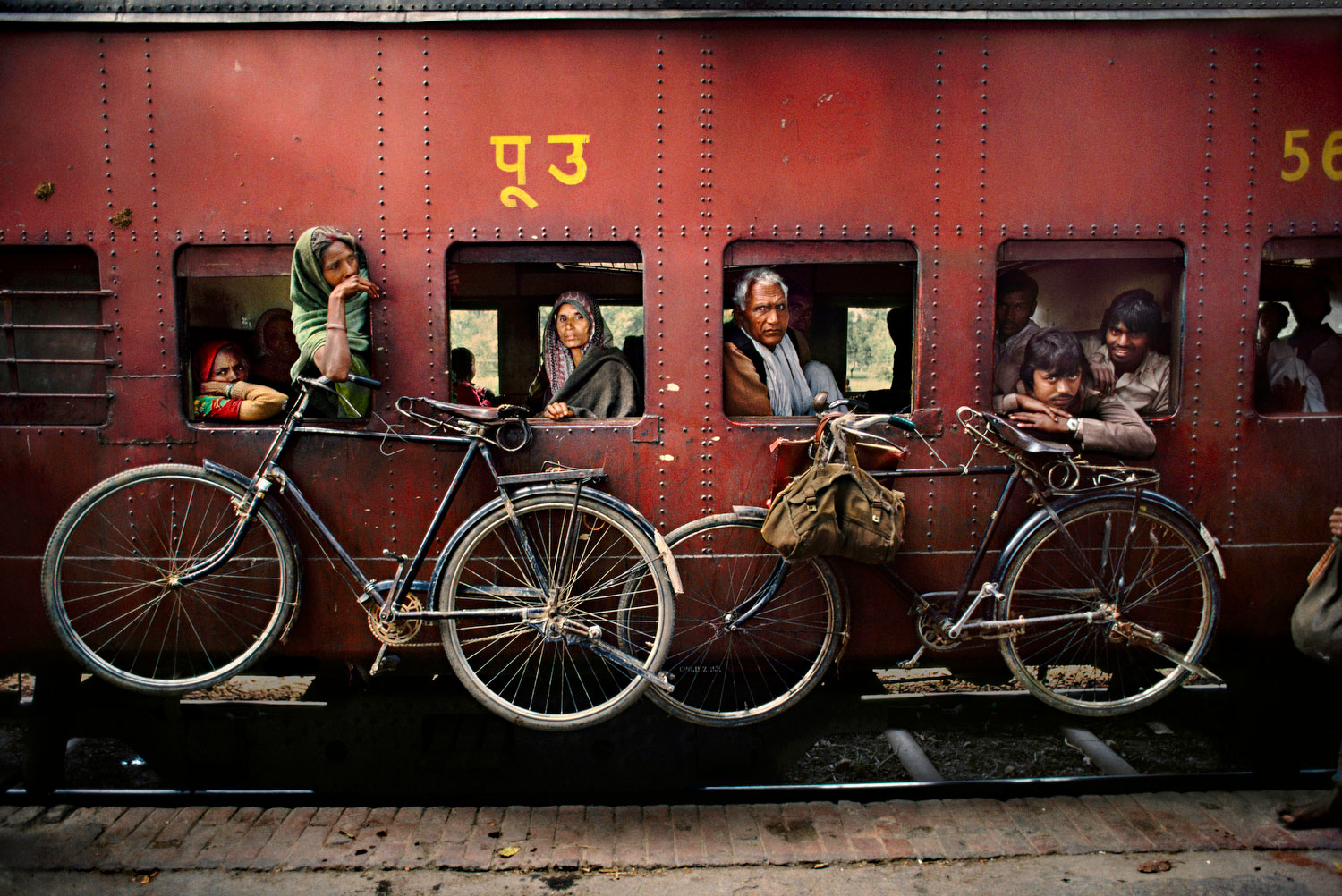 Alle Fotos © Steve McCurry”  “aus Indien (Prestel Verlag, 2015)” Westbengalen, 1983. Fahrräder hängen an der Aussenwand eines Eisenbahnwaggons.